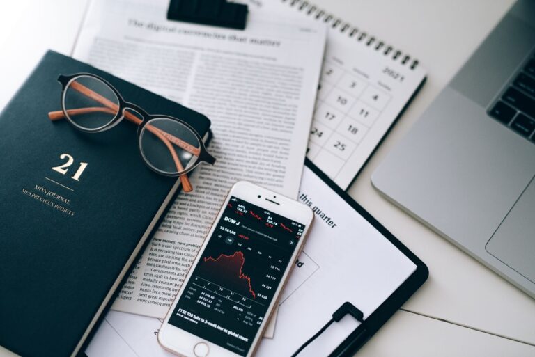 Financial documents, reading glasses and a phone showing a stock chart, for a guide to OpenAI exposure in filings